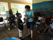 A teacher helping students with a hands-on activity at a table
