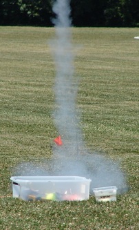 Smoke rising from a student-built rocket launched at a YES program